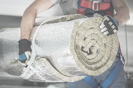 Caucasian Contractor Worker in His 40s with Roll of Mineral Wool Insulation in His Hands Preparing For Commercial Building Walls Insulation.